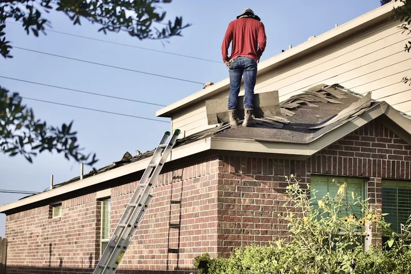 Professional roofer working on a residential roof in Parkview Bedford